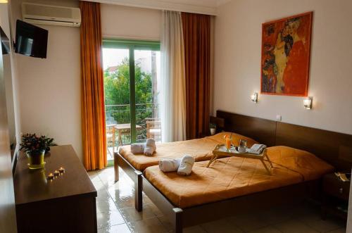 sypialnia z dużym łóżkiem i oknem w obiekcie Hotel Kostis w mieście Skiatos