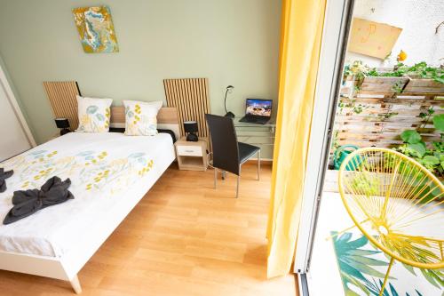 a bedroom with a bed and a desk and chairs at Duplex- T2 Barcelona Pop - Terrasses - Parking - Vue canal in Toulouse