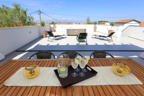 einen Tisch mit Gläsern und Stühlen auf dem Balkon in der Unterkunft Villa Tea in Zadar