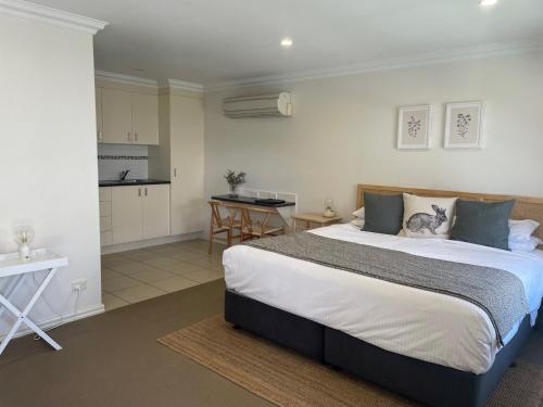 a bedroom with a large bed and a kitchen at Millthorpe Motel in Millthorpe