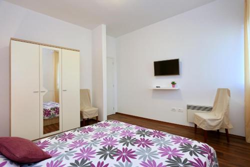 ein Schlafzimmer mit einem Bett und einem TV an der Wand in der Unterkunft Villa Tea in Zadar