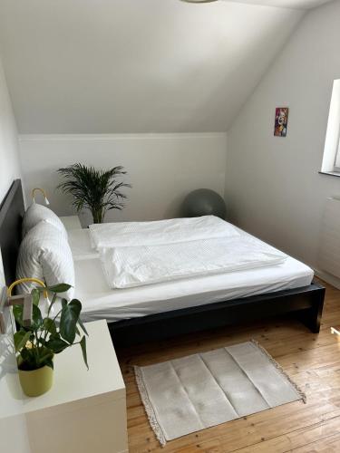 a white bedroom with a bed and a table at Ferienhaus Bernhard in Stubenberg