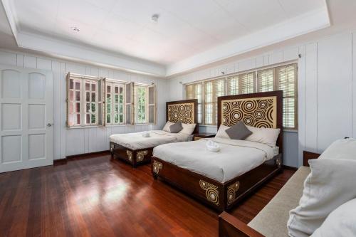 a bedroom with two beds and a couch and windows at Private Beach Villa in Anza Mactan with Ocean View in Punta Engaño