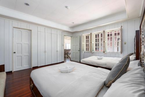 a bedroom with two beds with white walls and wooden floors at Private Beach Villa in Anza Mactan with Ocean View in Punta Engaño