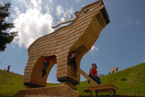 a woman is standing on a statue of a horse at Ferienwohnung Schaupphof in Donnersbachwald