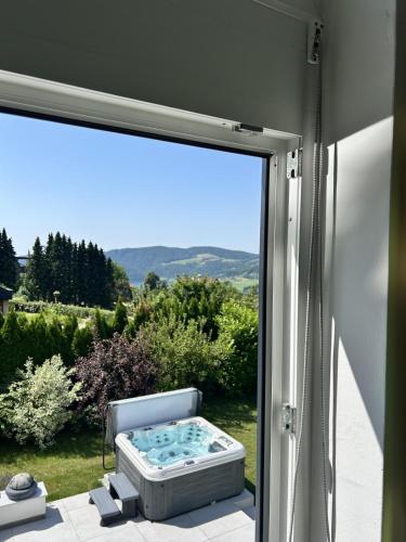 a sliding glass door with a hot tub outside at Ferienhaus Bernhard in Stubenberg