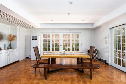a dining room with a wooden table and chairs at Private Beach Villa in Anza Mactan with Ocean View in Punta Engaño