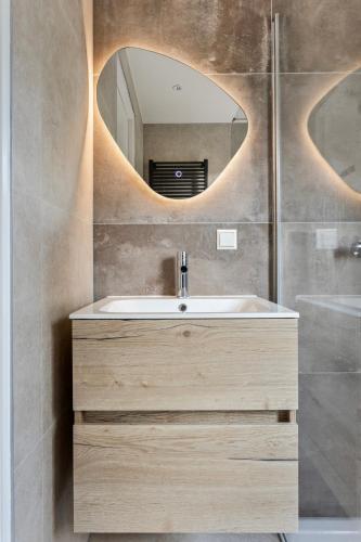 a bathroom with a sink and a mirror at Lodge 't Hert - Nieuwe lodge met vrij uitzicht & omheinde tuin in Putten