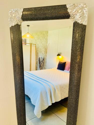 a mirror in a bedroom with a bed in it at L'Etape du Bonheur in Cilaos