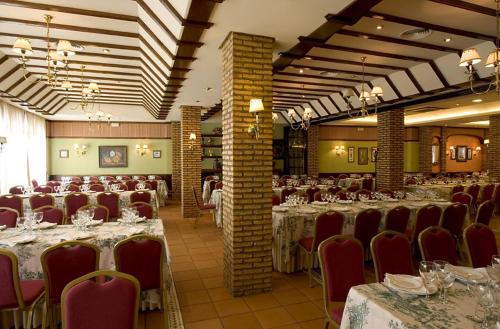 salę bankietową ze stołami i krzesłami w restauracji w obiekcie Hotel Manolo Mayo w mieście Los Palacios y Villafranca