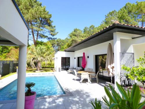 une maison avec une piscine et une terrasse dans l'établissement VILLA LUCIA, moderne avec piscine tempérée, ping pong, proche plage à Vieux-Boucau, à Vieux-Boucau-les-Bains