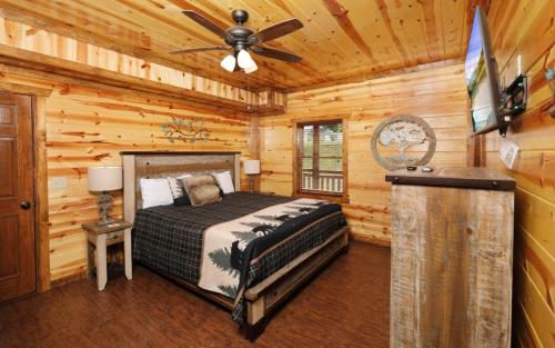 a bedroom with a bed and a ceiling fan at Dip in the Smokies in Gatlinburg