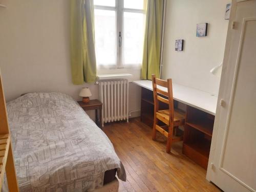 une chambre avec un lit, un bureau et une fenêtre dans l'établissement Appartement 302, à Montreuil