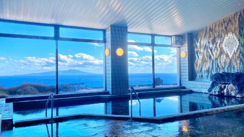 a swimming pool with a view of the ocean at Itoen Hotel Atagawa in Higashiizu