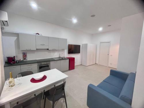 a kitchen with a blue chair and a white table at Giannina House 22 in Cefalù