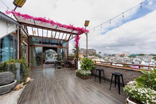 a balcony of a building with pink flowers on it at Jodi Dalat Hotel in Da Lat