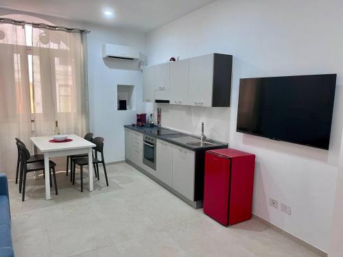 a kitchen with a small table and a red refrigerator at Giannina House 22 in Cefalù