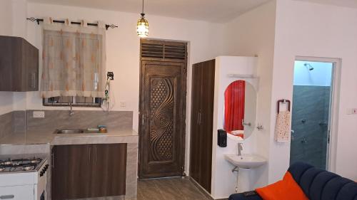 a kitchen with a wooden door and a sink at Nestabs Homes in Mtwapa