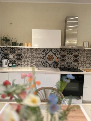a kitchen with black and white tile on the wall at Pelikan Lake House in Shkodër