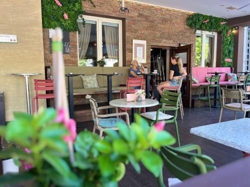 two women sitting at tables and chairs on a patio at Prenočišča Zvezda in Ljutomer