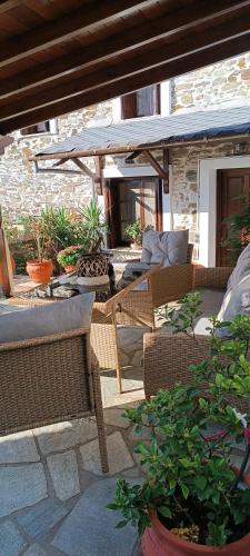 a patio with wicker chairs and tables and plants at Hope Nest Pelion in Zagora