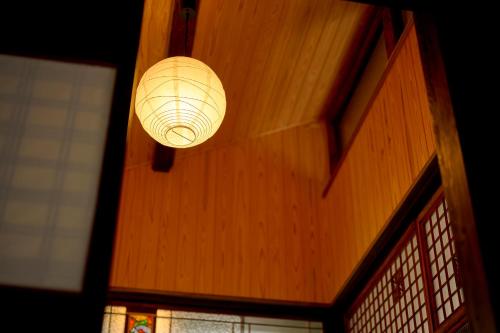 a light fixture hanging from a wooden wall at 鞆猫庵 Tomo Nyahn in Fukuyama