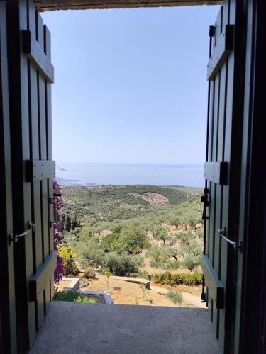 an open door looking out at a view of a field at Tzouzos-Kordopateika villa in Prosilio, Kardamyli in Prosílion