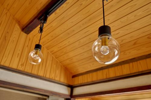 three lights hanging from the ceiling of a room at 鞆猫庵 Tomo Nyahn in Fukuyama