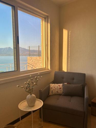 a living room with a couch and a large window at Pelikan Lake House in Shkodër