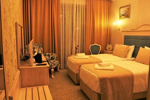 a hotel room with two beds and a television at Vendome Hotel in Eskisehir