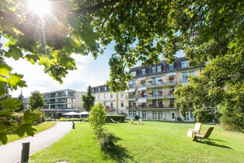 a building with a park in front of it at Park-Hotel am Rhein - Gesundheitshotel und Residenzen in Rheinfelden