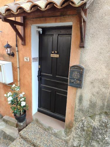 une porte noire avec un panneau devant elle dans l'établissement La Maison des Roches' Casteaux, à Entrecasteaux