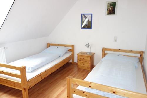 a bedroom with two beds and a night stand at Bertelemühle in Günzburg