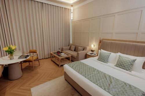 a hotel room with a bed and a couch at The Tivoli New Delhi in New Delhi