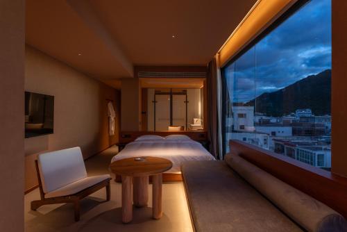 a hotel room with a bed and a large window at Roy Hotel-Tianya Town Store in Sanya