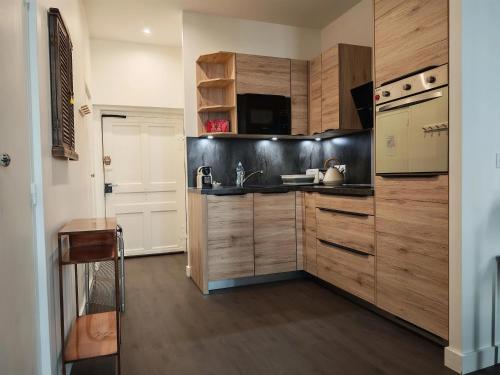 une cuisine avec des armoires en bois et un évier dans l'établissement Le Studio Sainte Claire, à Annecy