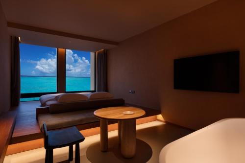a living room with a view of the ocean at Roy Hotel-Tianya Town Store in Sanya