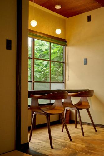 a table and two chairs in a room with a window at 海月 うみづき in Tomo