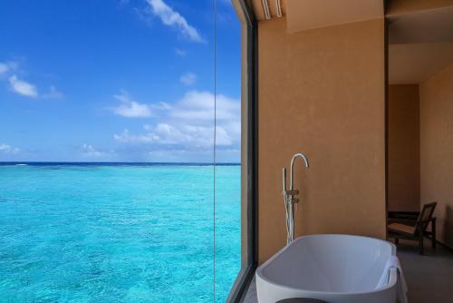 a bathroom with a tub and a view of the ocean at Roy Hotel-Tianya Town Store in Sanya