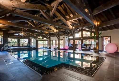 an indoor pool in a house with wooden ceilings at Hotel Tsanteleina in Val dʼIsère
