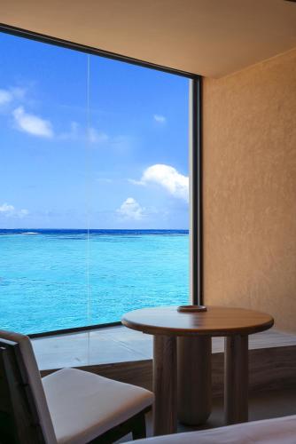 a room with a table and a view of the ocean at Roy Hotel-Tianya Town Store in Sanya