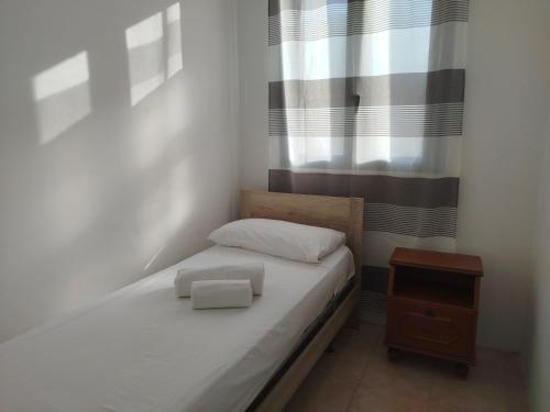 a small bedroom with a bed and a window at Casa vacanze La canzone del sole in Torre Squillace