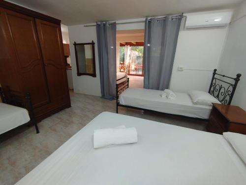 a bedroom with two beds and a door to a patio at Casa vacanze La canzone del sole in Torre Squillace
