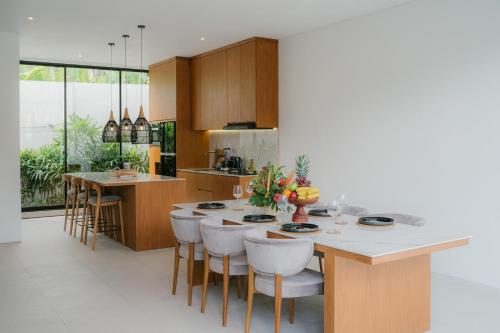 a kitchen with a table and some chairs and a counter at Modern 3BR Private Pool Villa 5-min Beach in Canggu