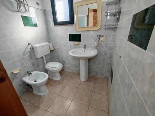 a bathroom with a toilet and a sink at Casa vacanze La canzone del sole in Torre Squillace