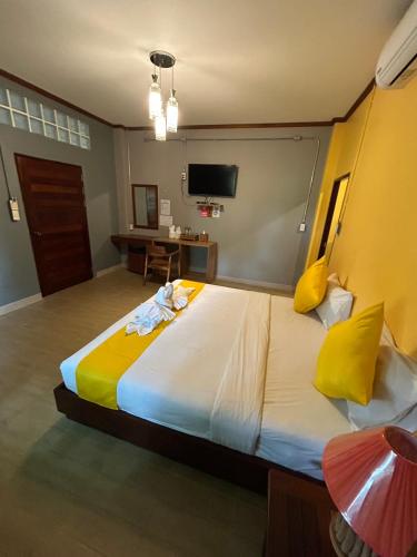 a bedroom with a large bed with yellow pillows at Araya Boutique Hotel in Thongsala