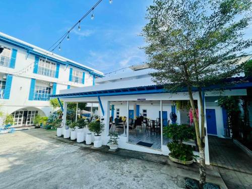 a white building with plants in front of it at Bernese Resort Hotel powered by Cocotel in Ligao
