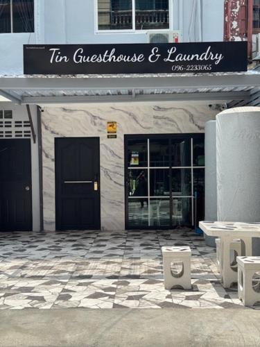 a store with a sign on the front of a building at Tin Guest House & Laundry in Jomtien Beach