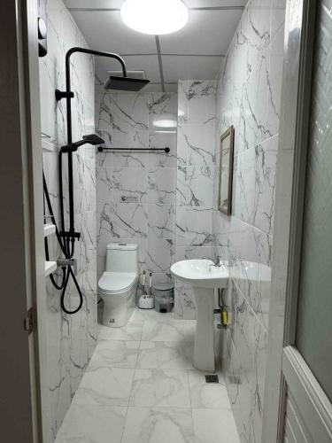 a white bathroom with a sink and a toilet at Tin Guest House & Laundry in Jomtien Beach