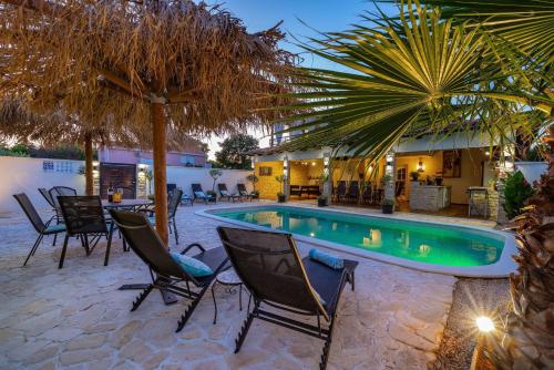 eine Terrasse mit Stühlen und einem Swimmingpool in der Unterkunft Villa Andrea ZadarVillas in Zaton